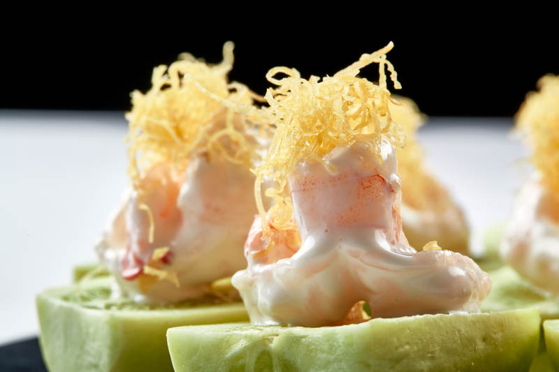 黑色瓷盘装的沙拉大虾仁图片