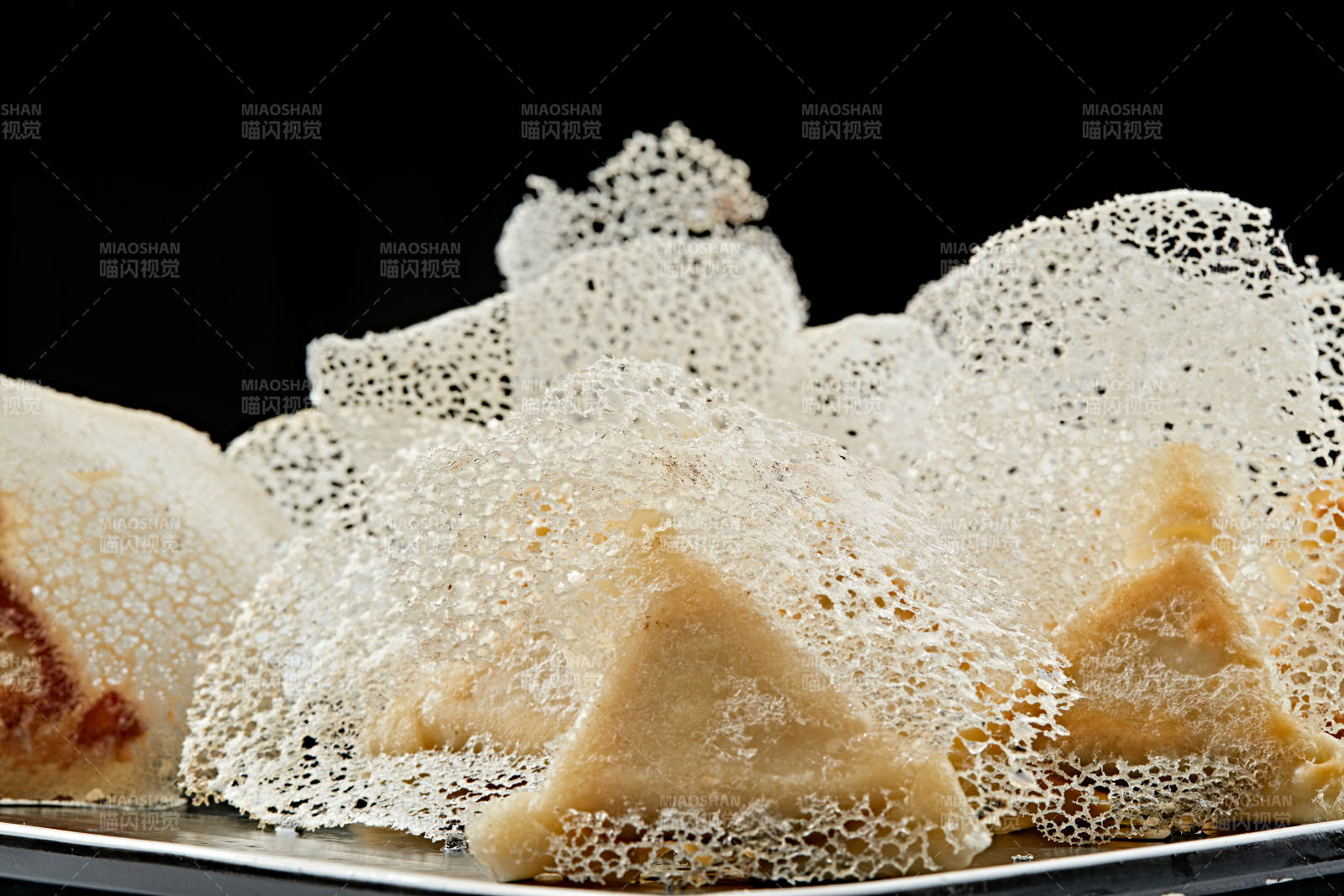 黑色瓷盘装的渔网水煎包图片