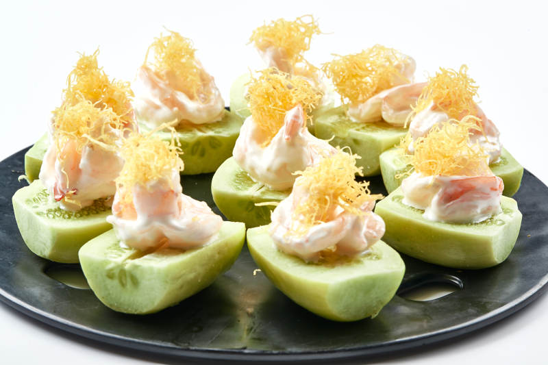 黑色瓷盘装的沙拉大虾仁图片