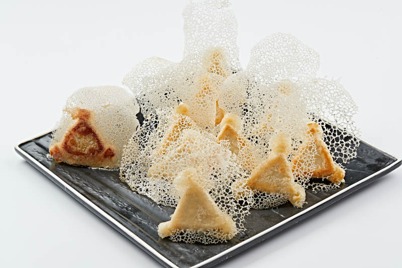 黑色瓷盘装的渔网水煎包图片