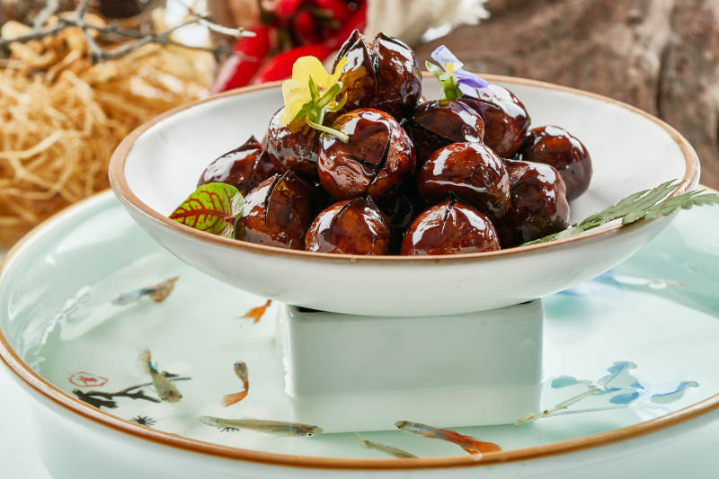 精美餐具装的糖焗开口板栗图片