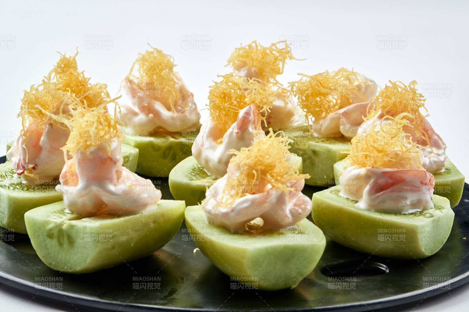 黑色瓷盘装的沙拉大虾仁图片