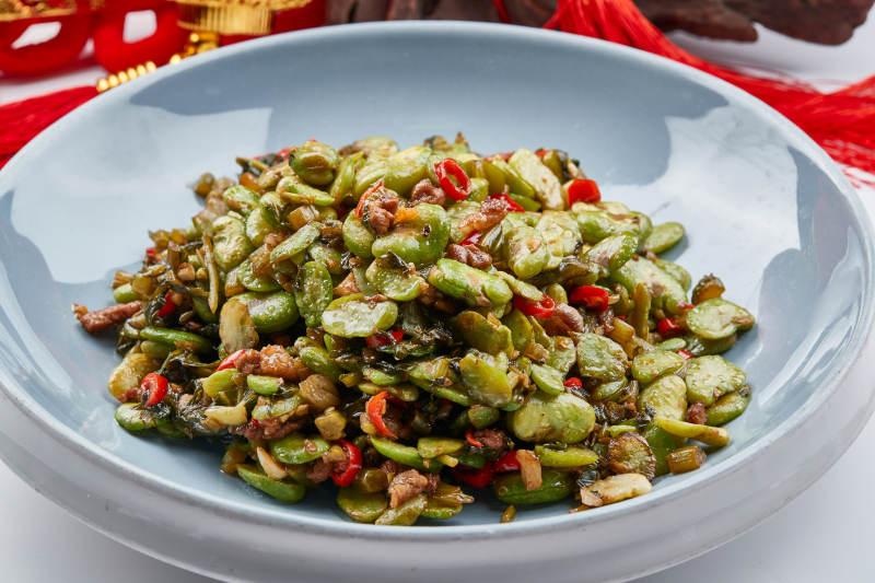 精美餐具装的香辣肉沫雪菜炒蚕豆图片