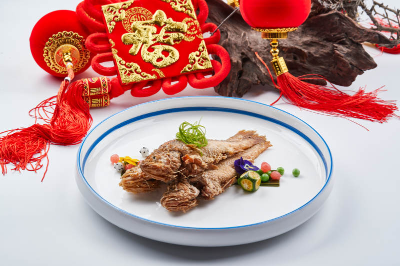 白色瓷盘装的油炸新鲜小黄鱼图片