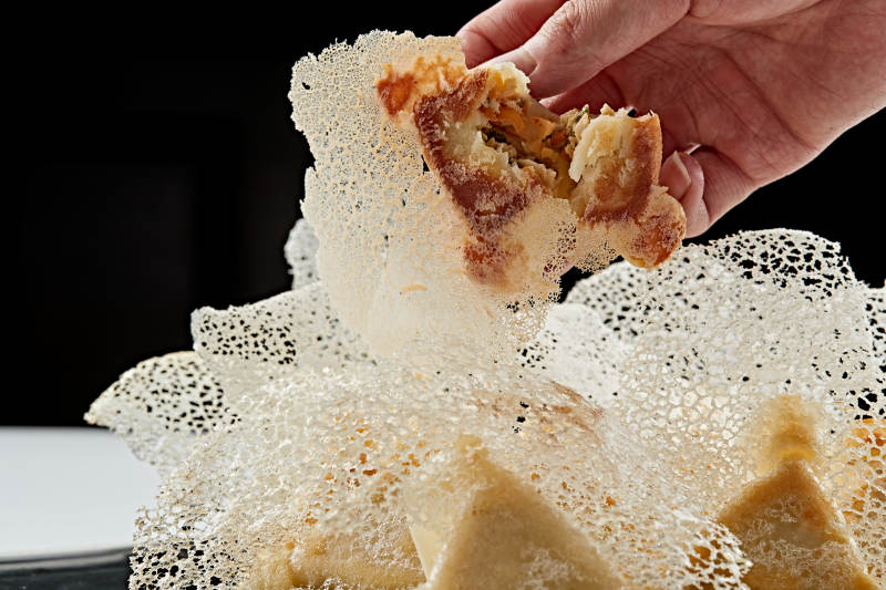 黑色瓷盘装的渔网水煎包图片