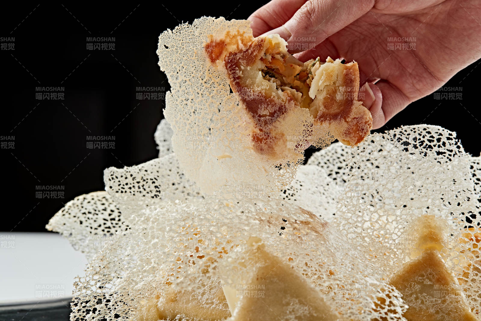 黑色瓷盘装的渔网水煎包图片