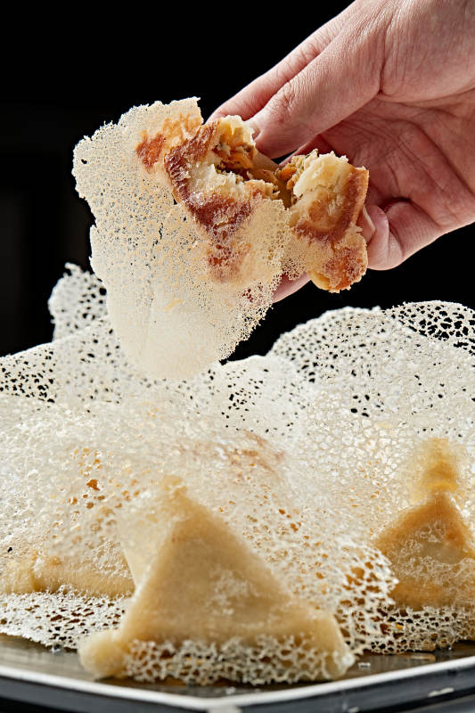 黑色瓷盘装的渔网水煎包图片