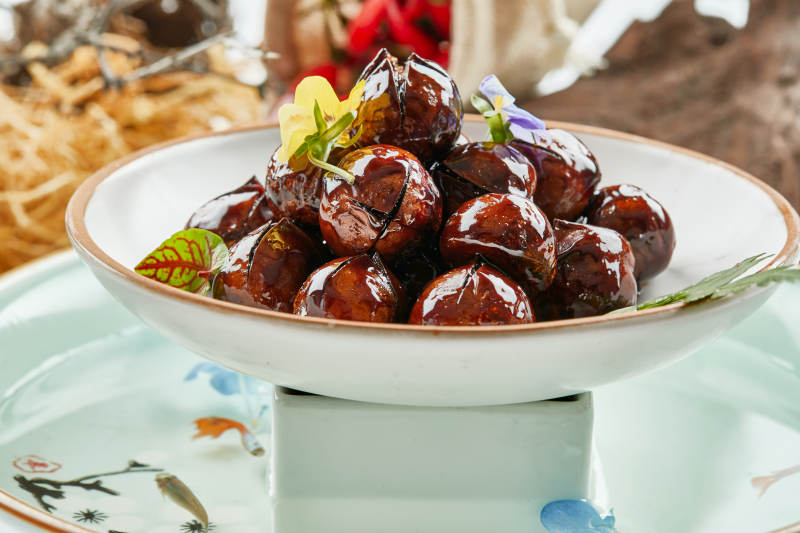 精美餐具装的糖焗开口板栗图片