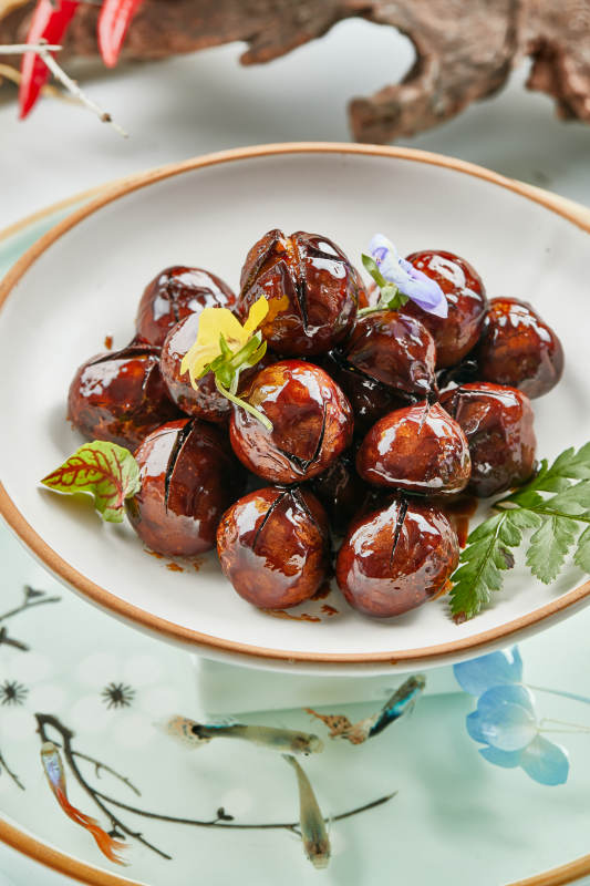 精美餐具装的糖焗开口板栗图片