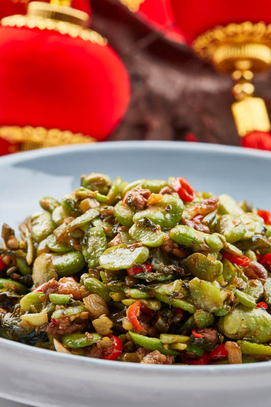 精美餐具装的香辣肉沫雪菜炒蚕豆图片