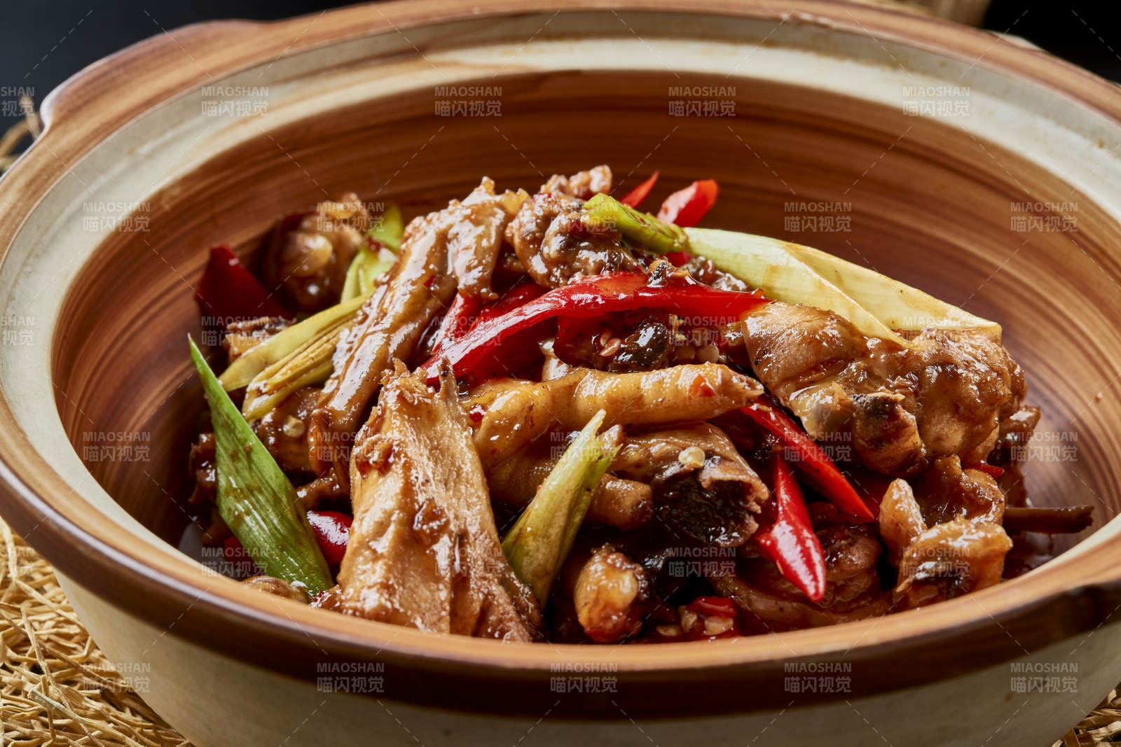 黑色背景上的砂锅酱香鸡块煲图片