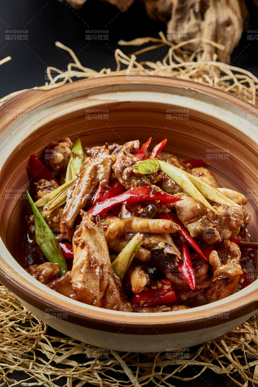 黑色背景上的砂锅酱香鸡块煲图片