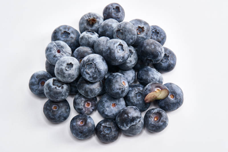 白色背景上摆放的水润新鲜蓝莓果图片