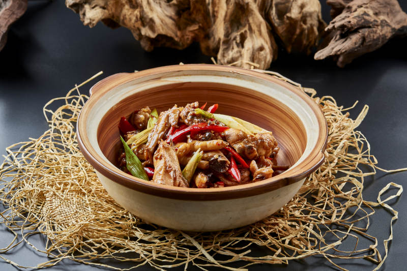 黑色背景上的砂锅酱香鸡块煲图片