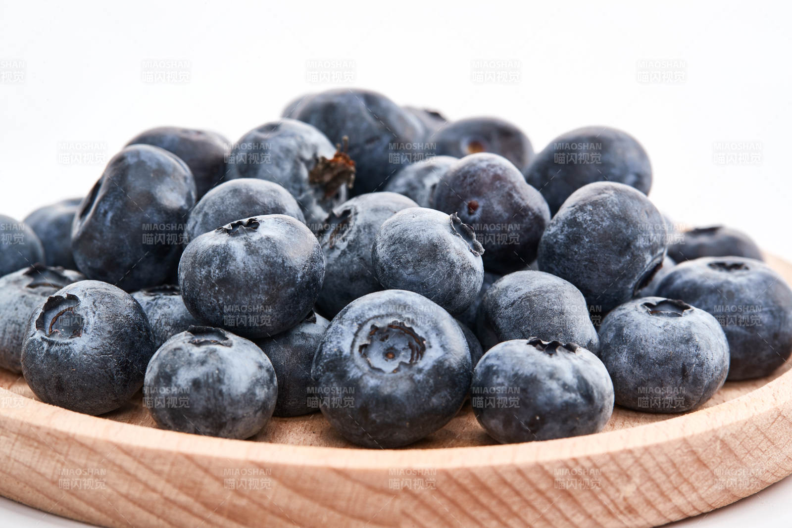 白色背景上摆放的水润新鲜蓝莓果图片