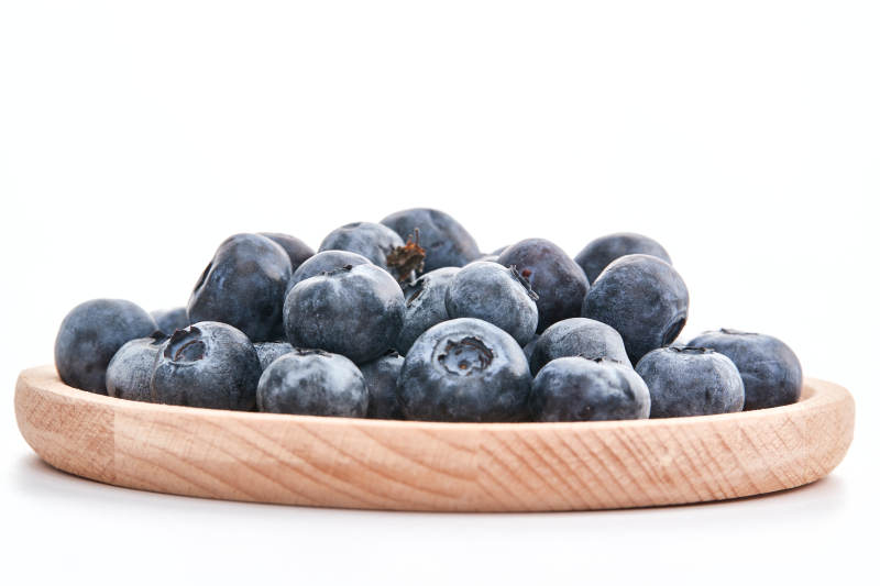 白色背景上摆放的水润新鲜蓝莓果图片