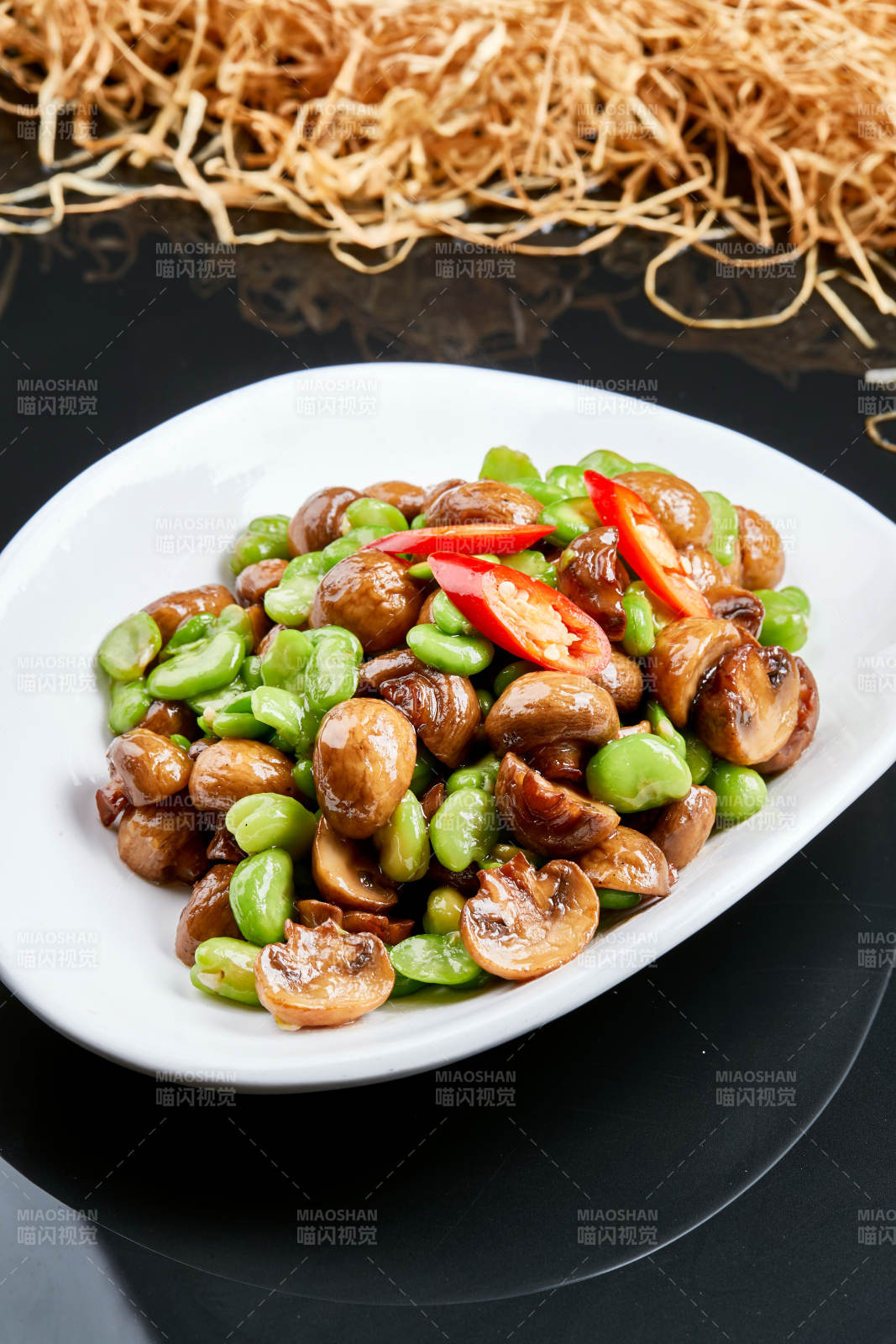 白色瓷盘装的塞外口蘑小炒青蚕豆图片