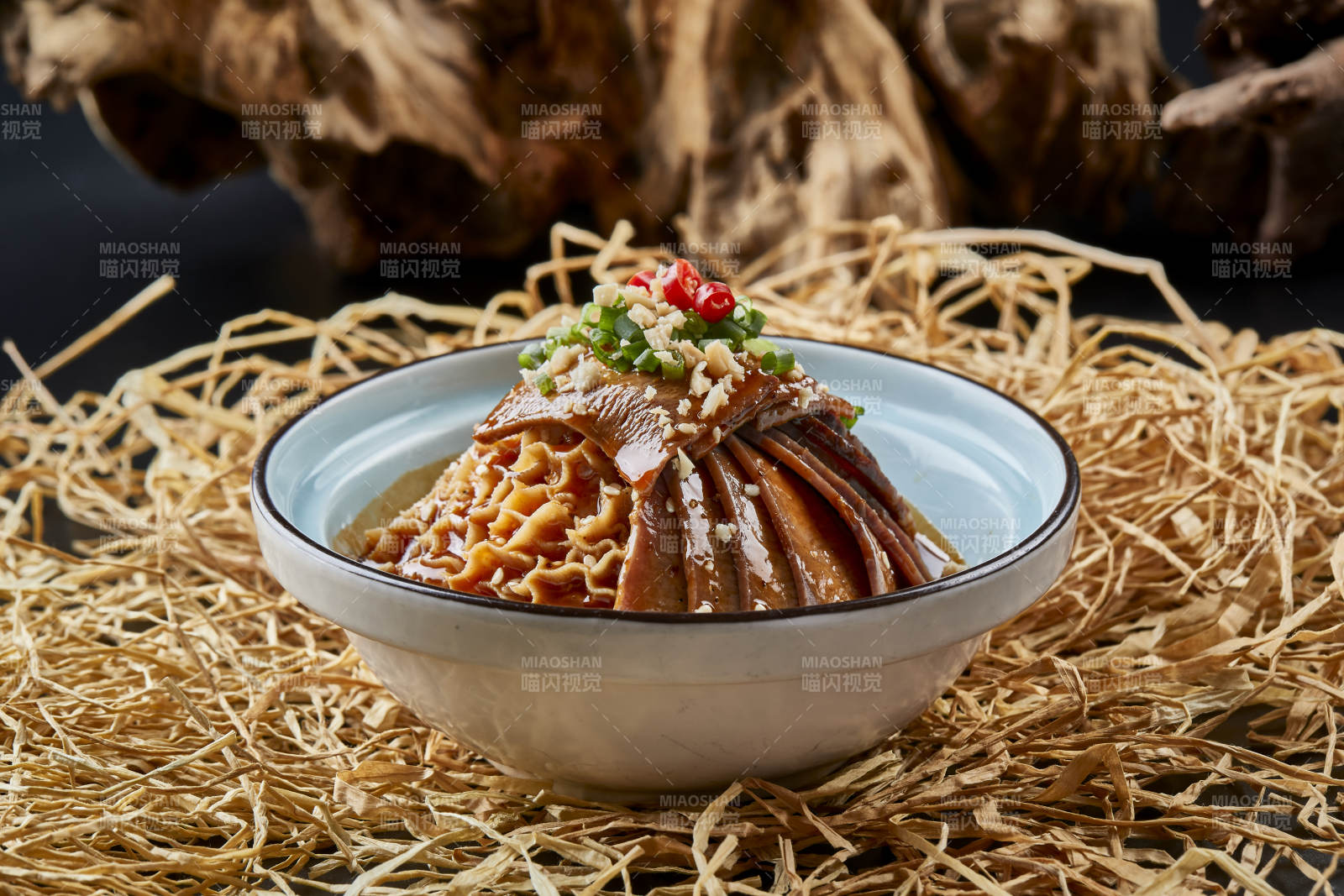 黑色背景上的瓷餐具装的川味夫妻肺片图片