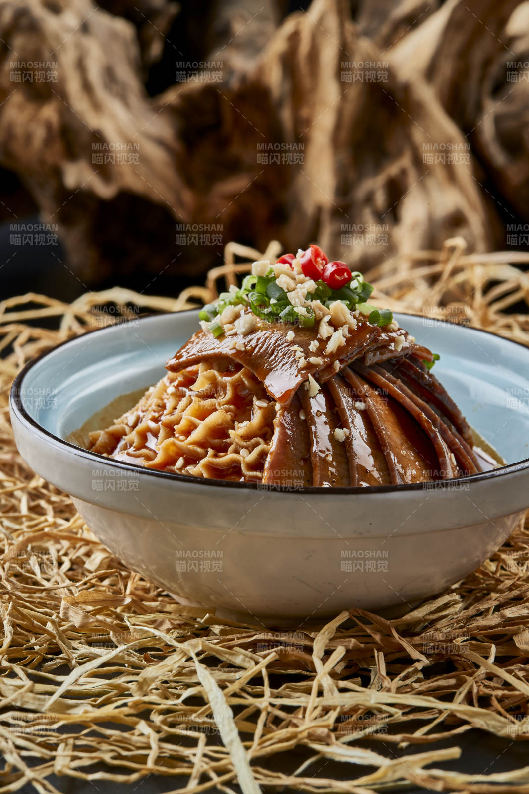 黑色背景上的瓷餐具装的川味夫妻肺片图片