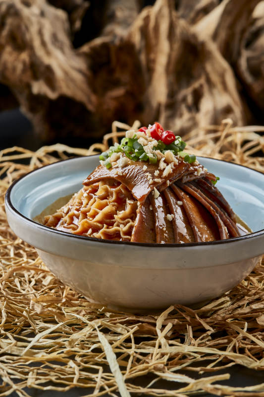 黑色背景上的瓷餐具装的川味夫妻肺片图片