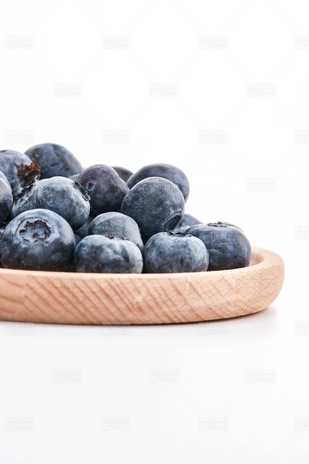 白色背景上摆放的水润新鲜蓝莓果图片