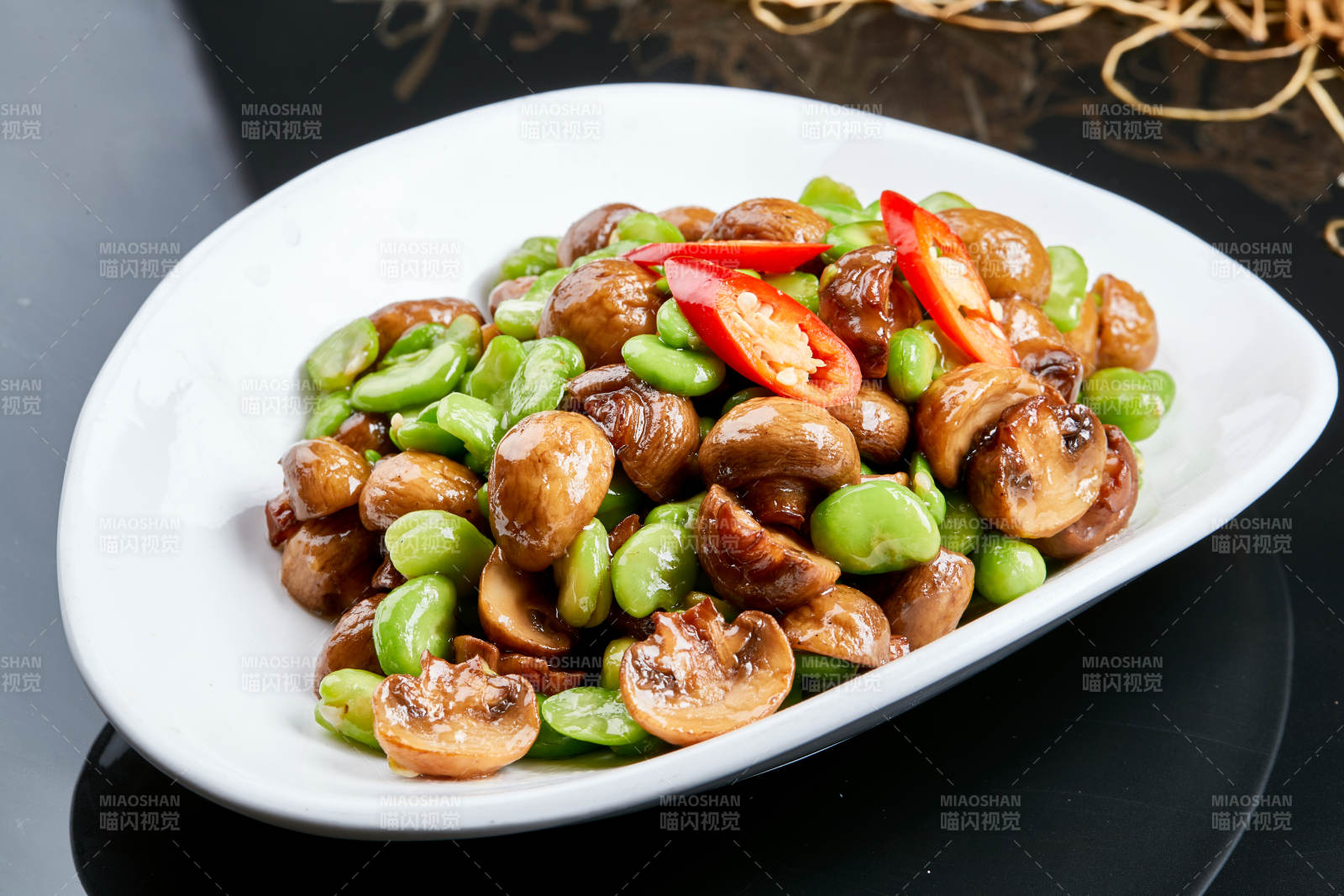 白色瓷盘装的塞外口蘑小炒青蚕豆图片