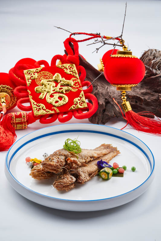 白色瓷盘装的油炸新鲜小黄鱼图片