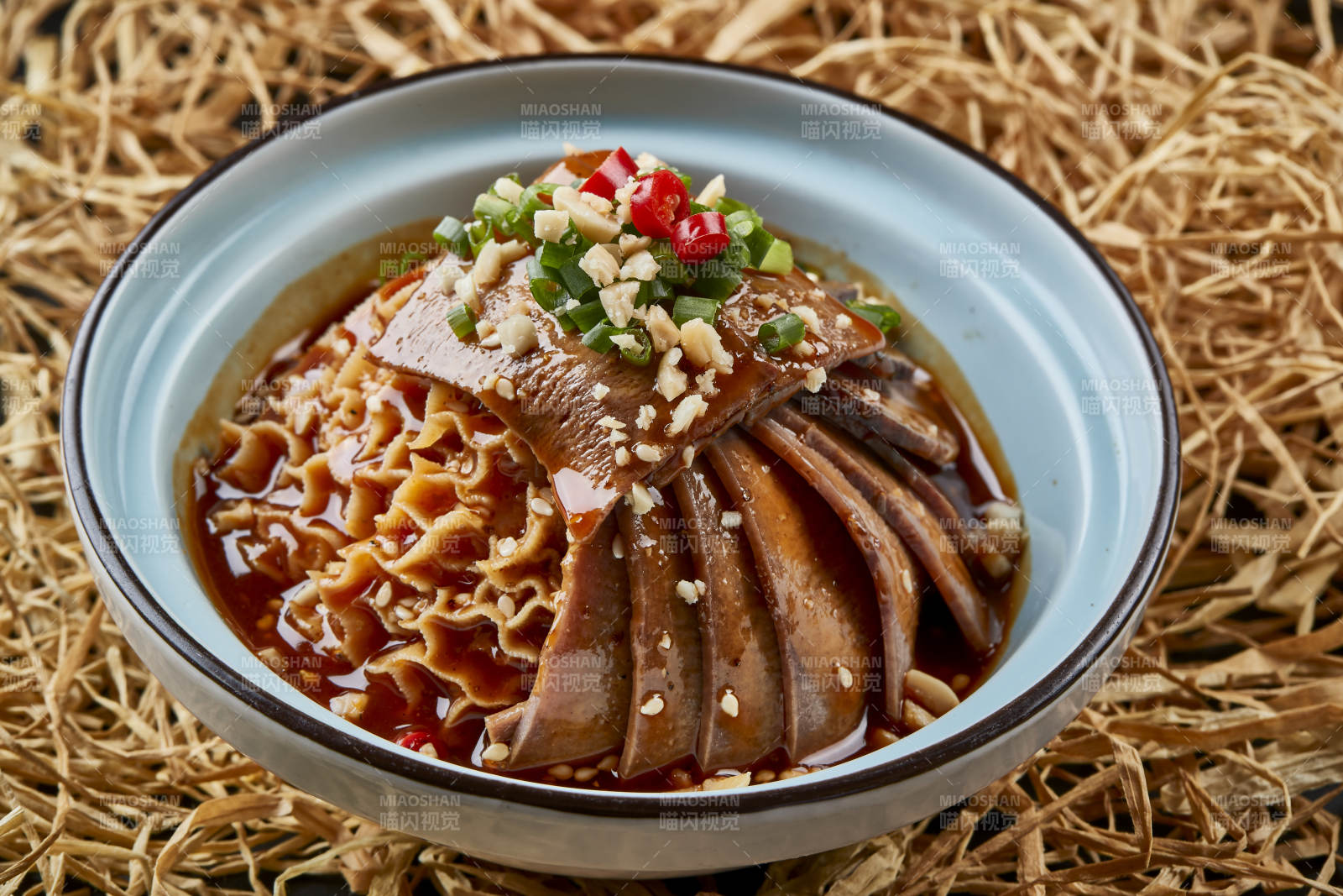 黑色背景上的瓷餐具装的川味夫妻肺片图片