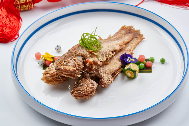 白色瓷盘装的油炸新鲜小黄鱼图片