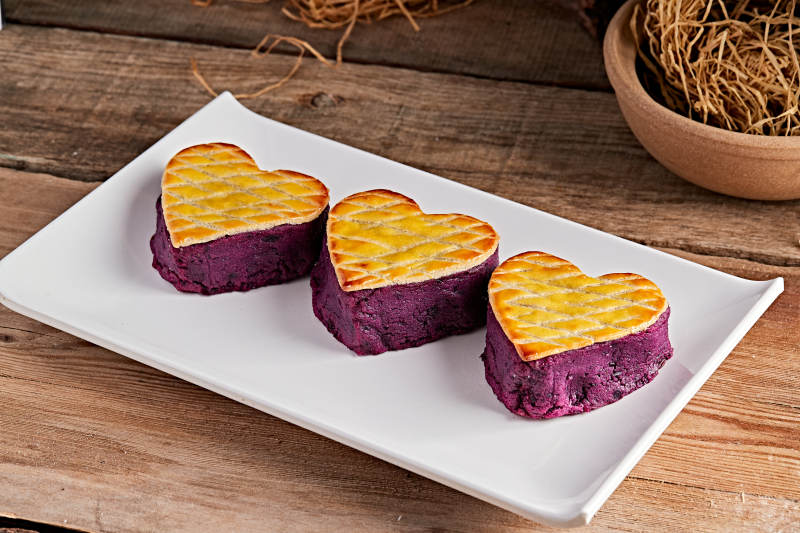 白色瓷盘装的茶餐烘焙酥皮心形紫薯泥图片