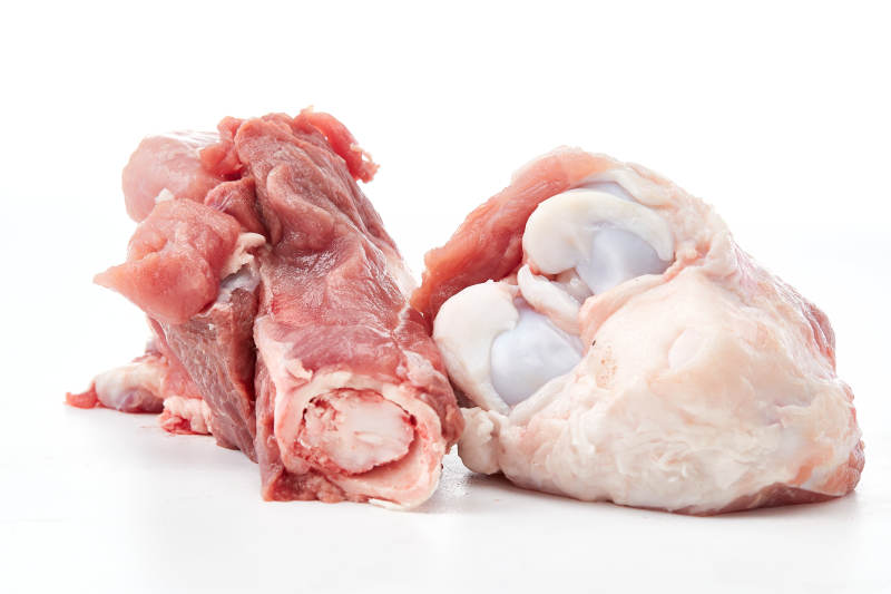 白色背景下的生鲜猪棒骨图片