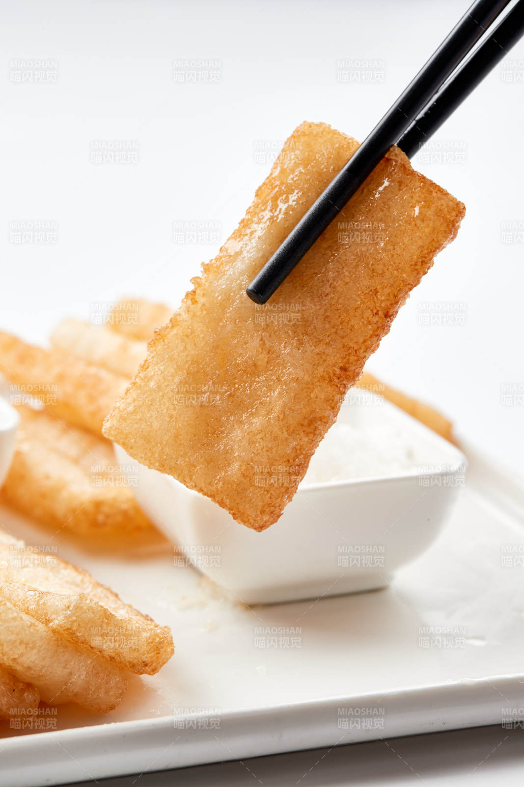 白色瓷盘装的美味香炸糯米糍粑图片