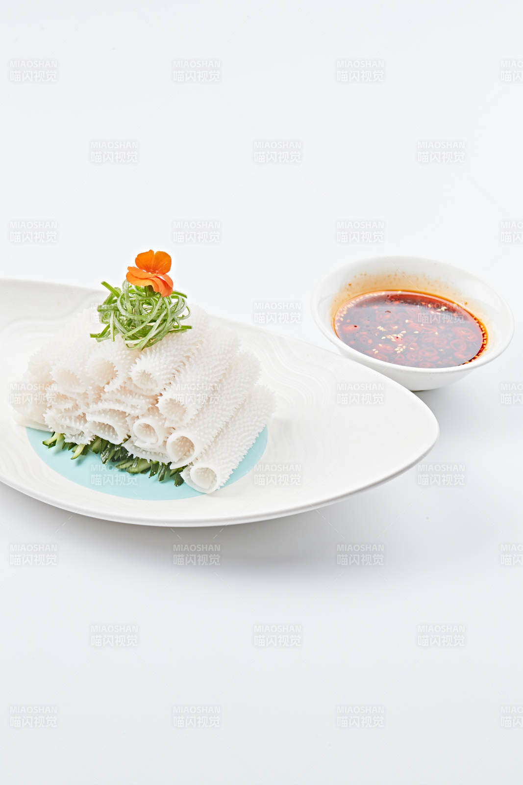 白色瓷盘装的红油墨鱼卷图片