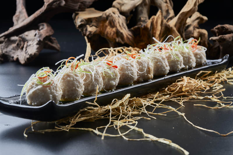 黑长瓷盘装的浇汁清汤萝卜丸子图片