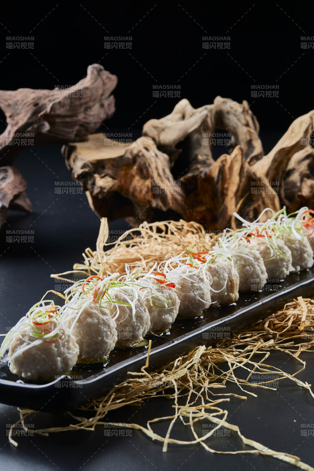 黑长瓷盘装的浇汁清汤萝卜丸子图片