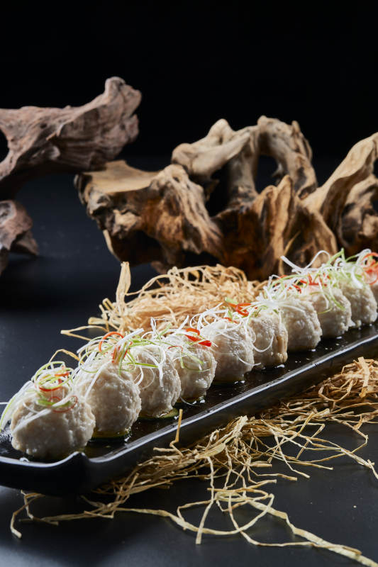 黑长瓷盘装的浇汁清汤萝卜丸子图片