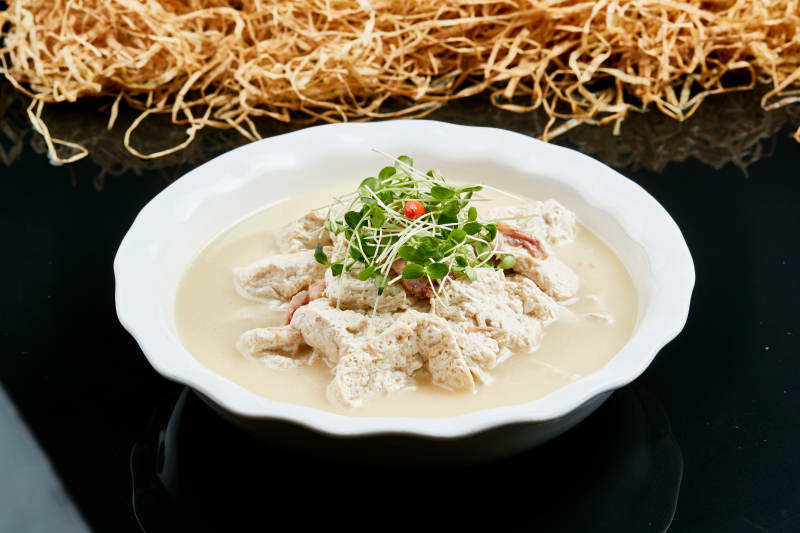 白色瓷餐具装的鲜鸡汤自制豆腐图片