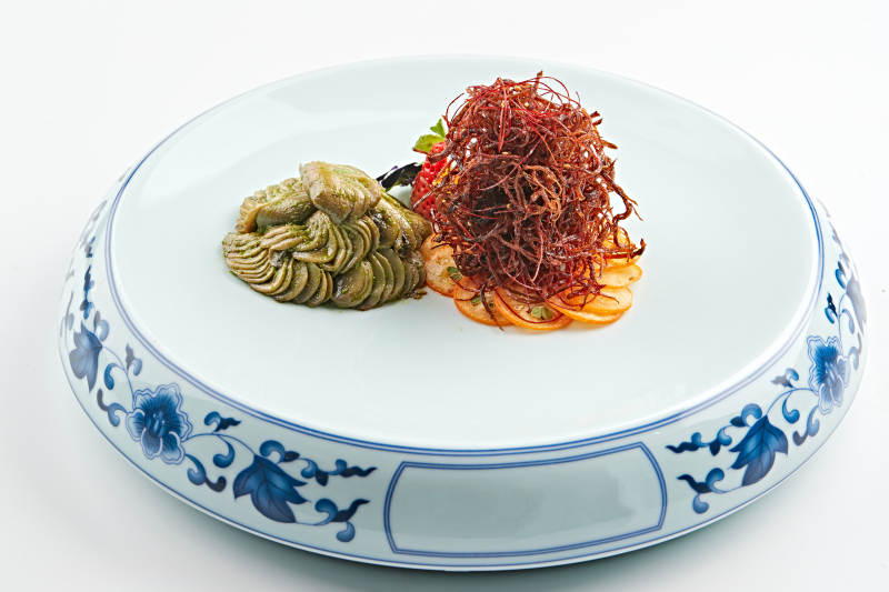 青花瓷盘装的腌渍口蘑配麻辣猪脯肉丝图片