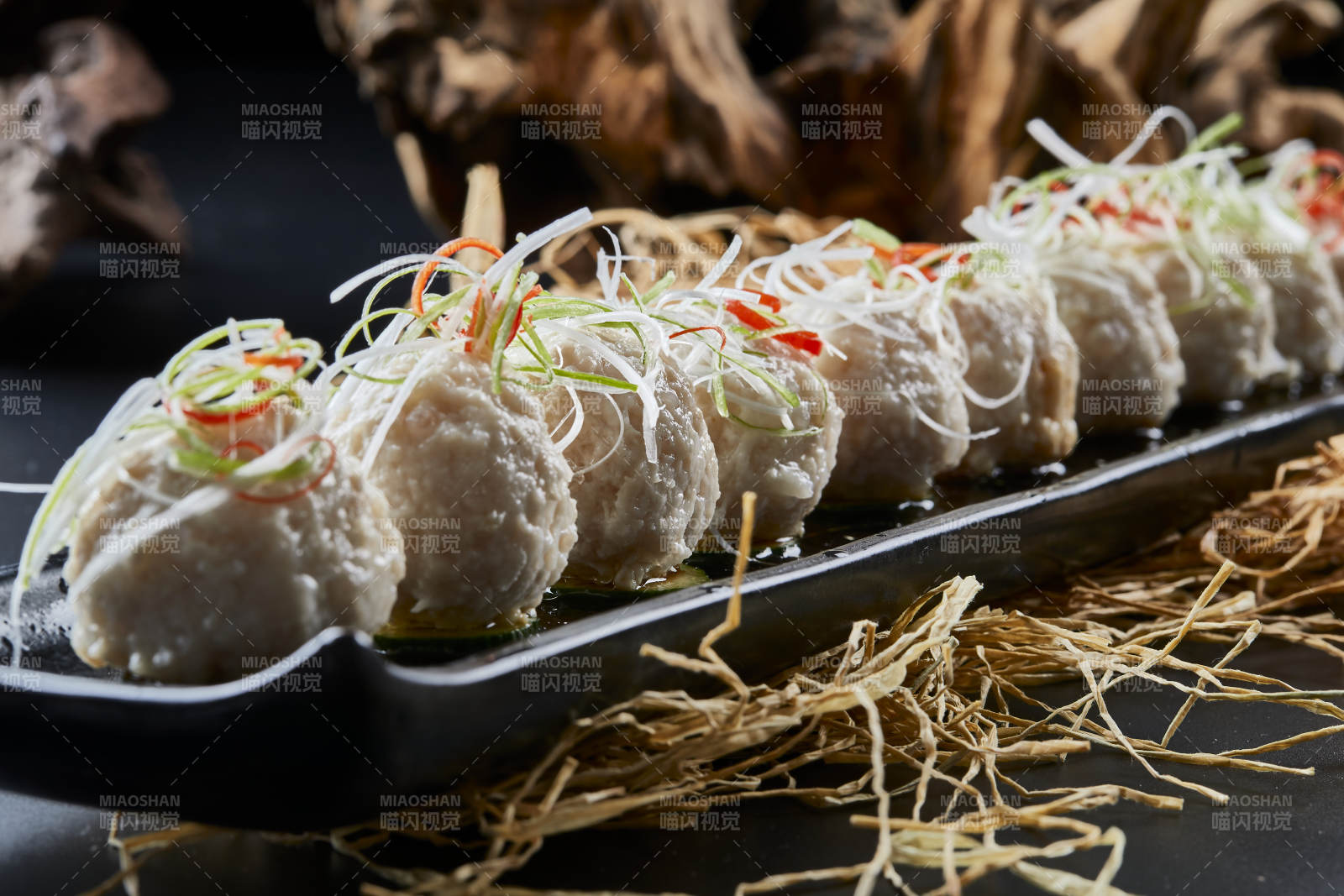 黑长瓷盘装的浇汁清汤萝卜丸子图片