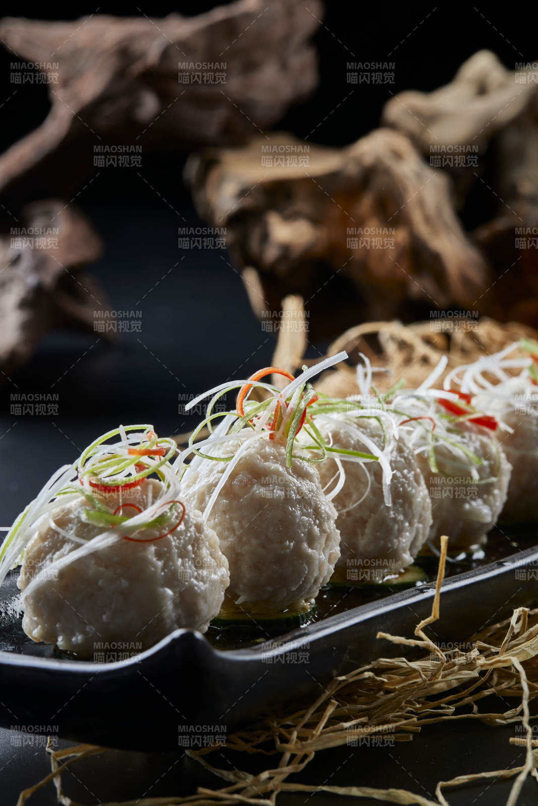 黑长瓷盘装的浇汁清汤萝卜丸子图片