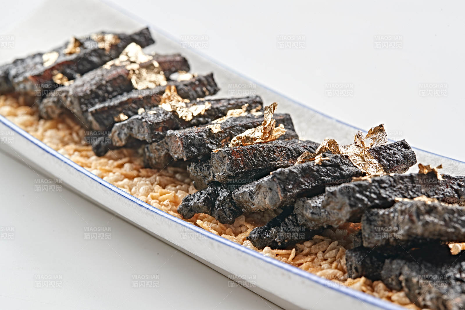 白色瓷盘装的墨鱼汁香煎猪五花肉图片