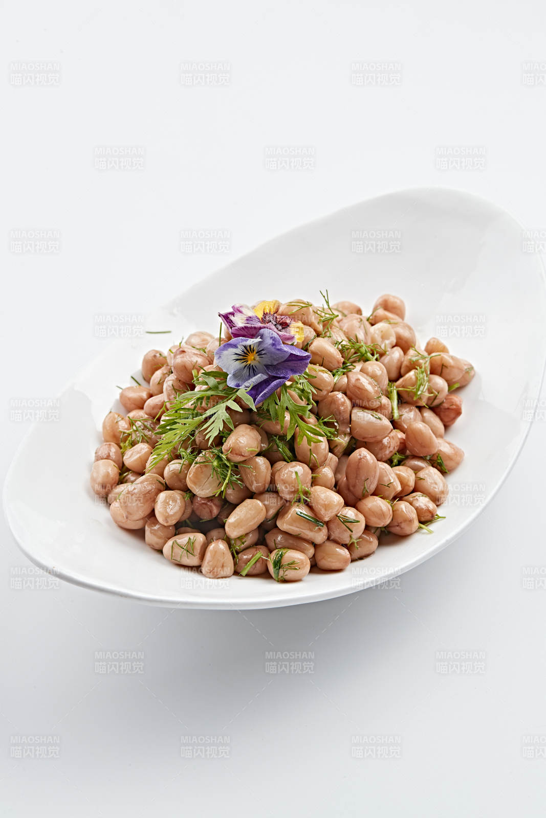 白色瓷盘装的茴香拌煮花生图片