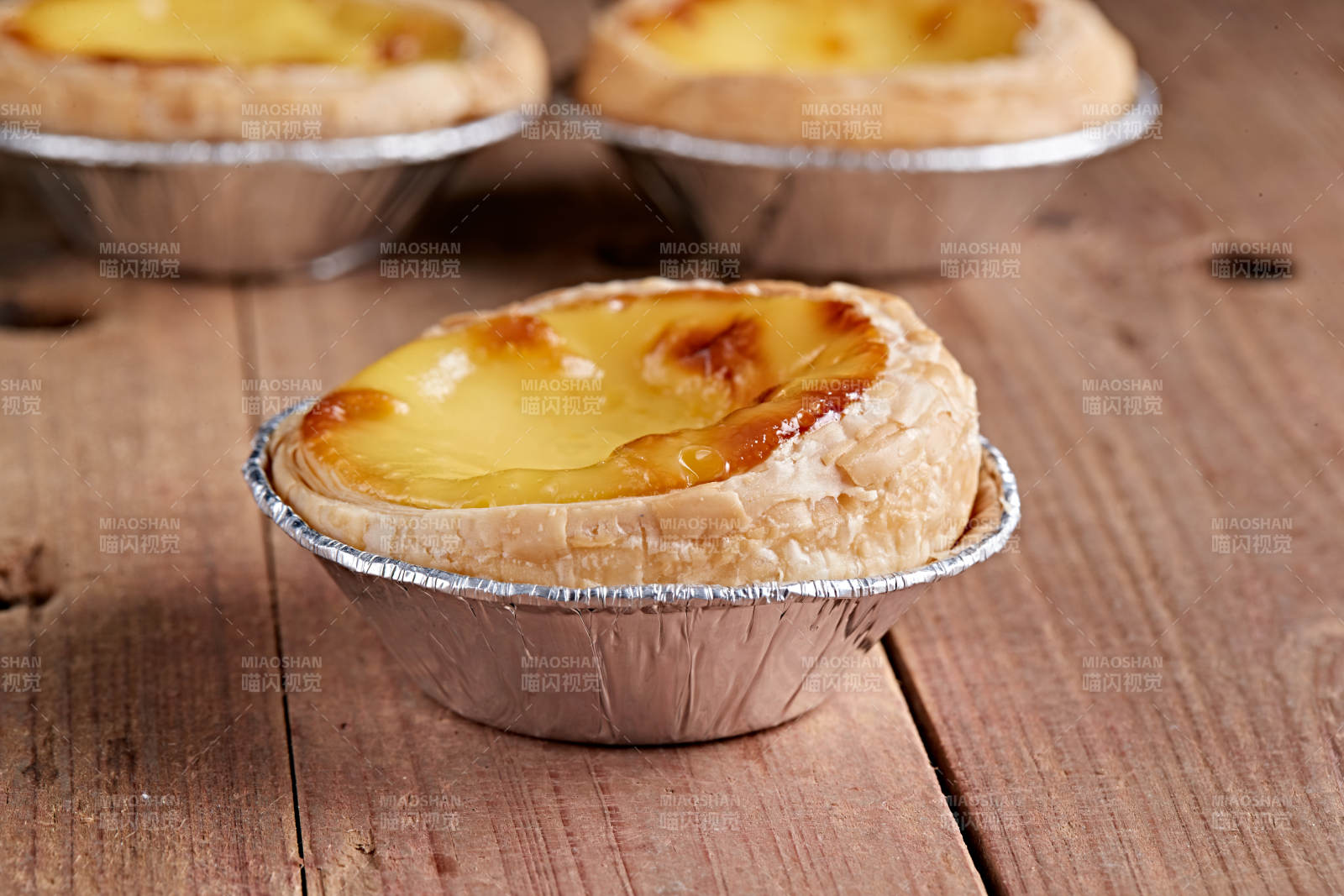 木板上的香烤葡式蛋挞图片