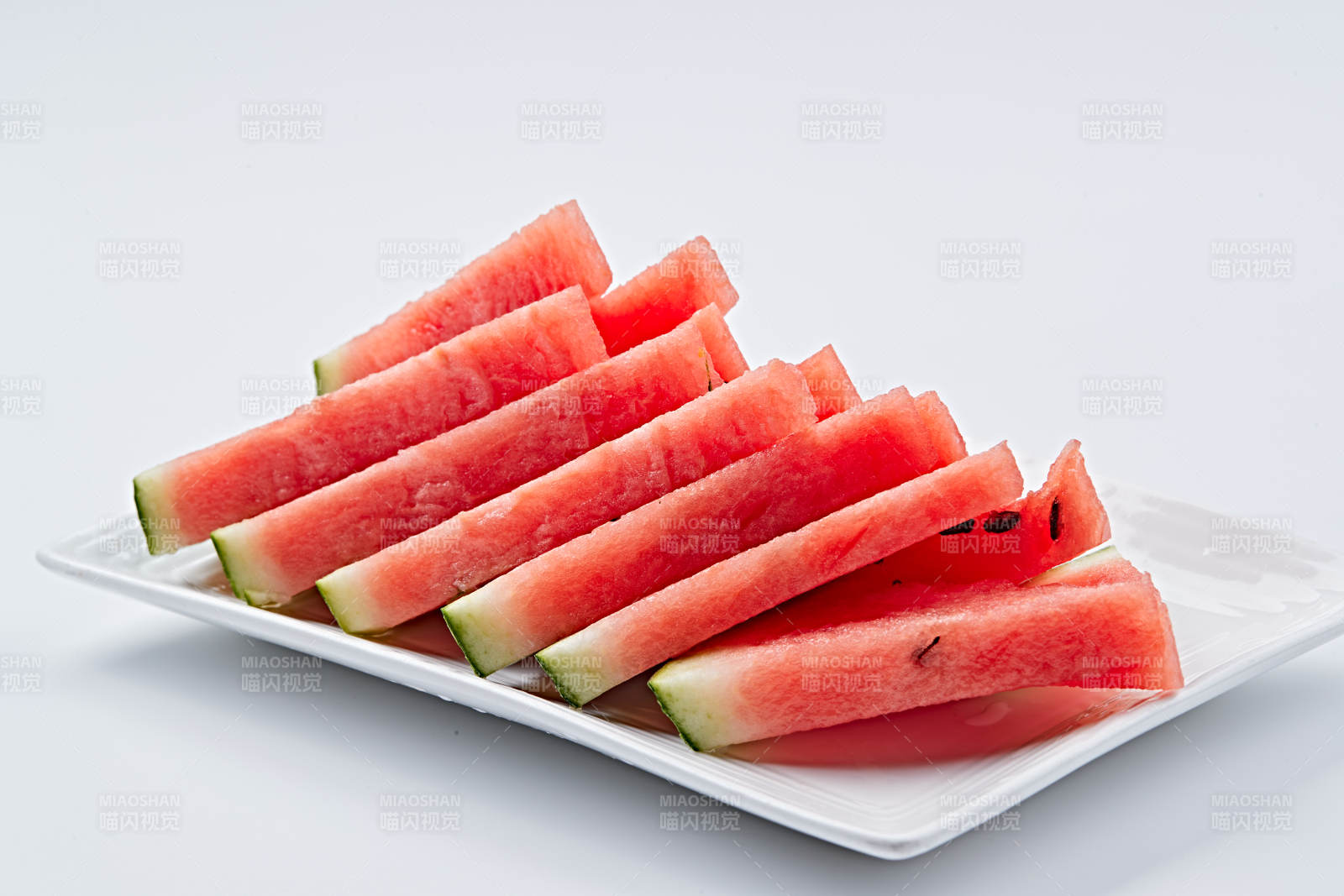 白色瓷盘装的切好的西瓜图片
