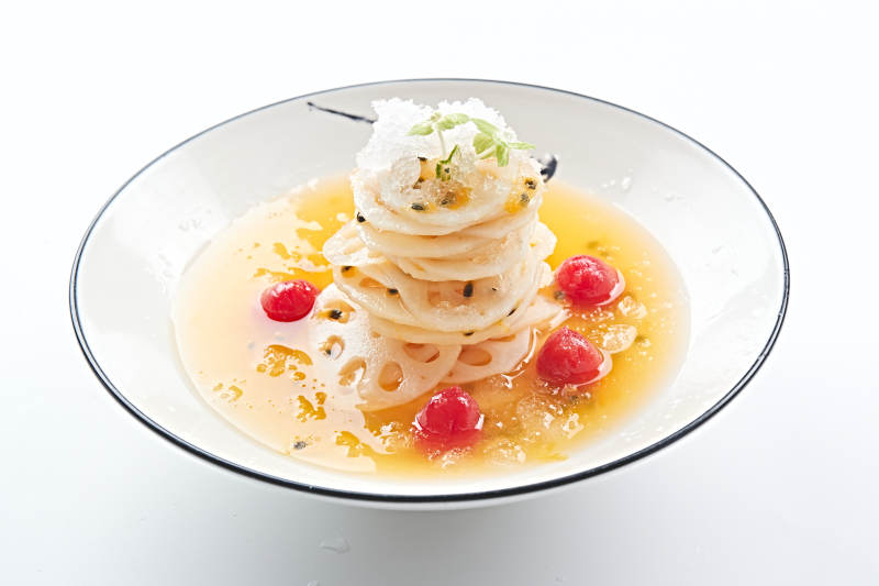 白色瓷盘装的橙汁冰镇莲藕片图片