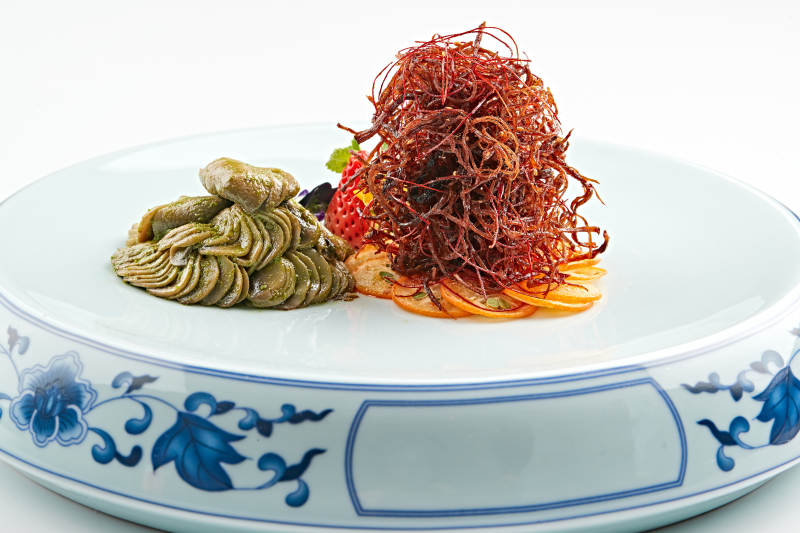 青花瓷盘装的腌渍口蘑配麻辣猪脯肉丝图片