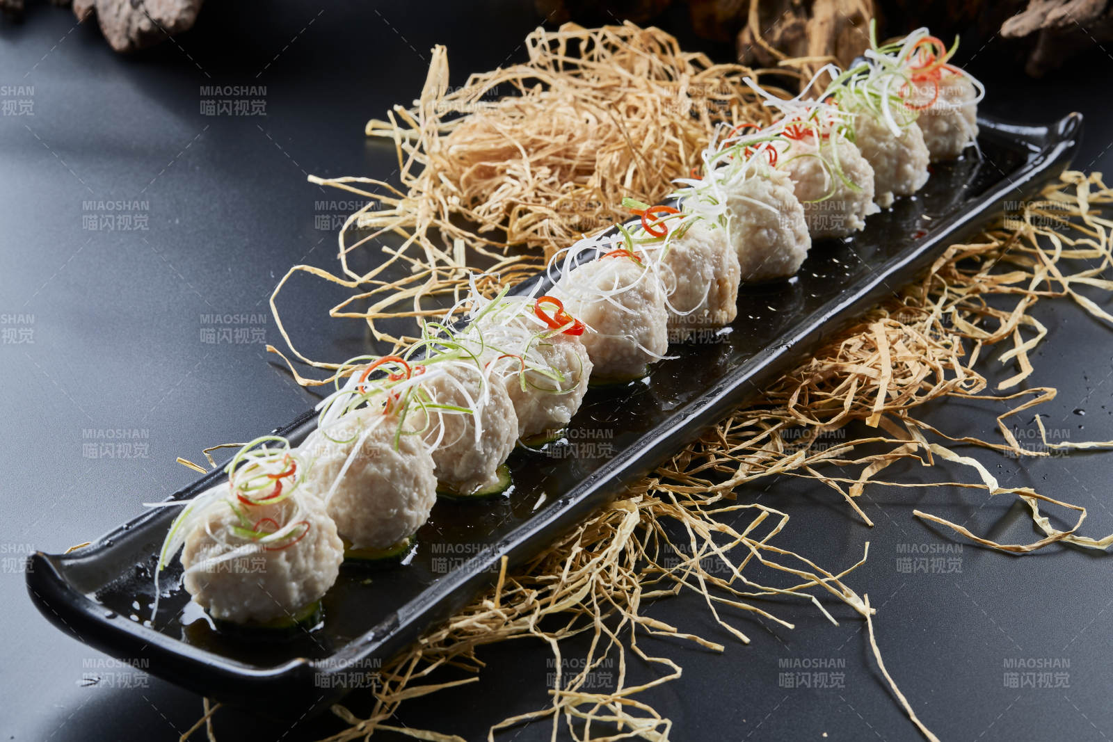 黑长瓷盘装的浇汁清汤萝卜丸子图片