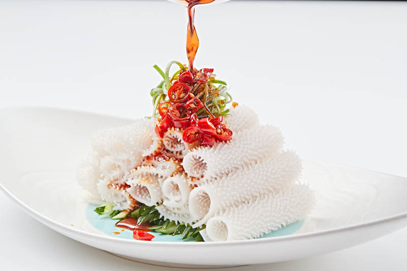 白色瓷盘装的红油墨鱼卷图片