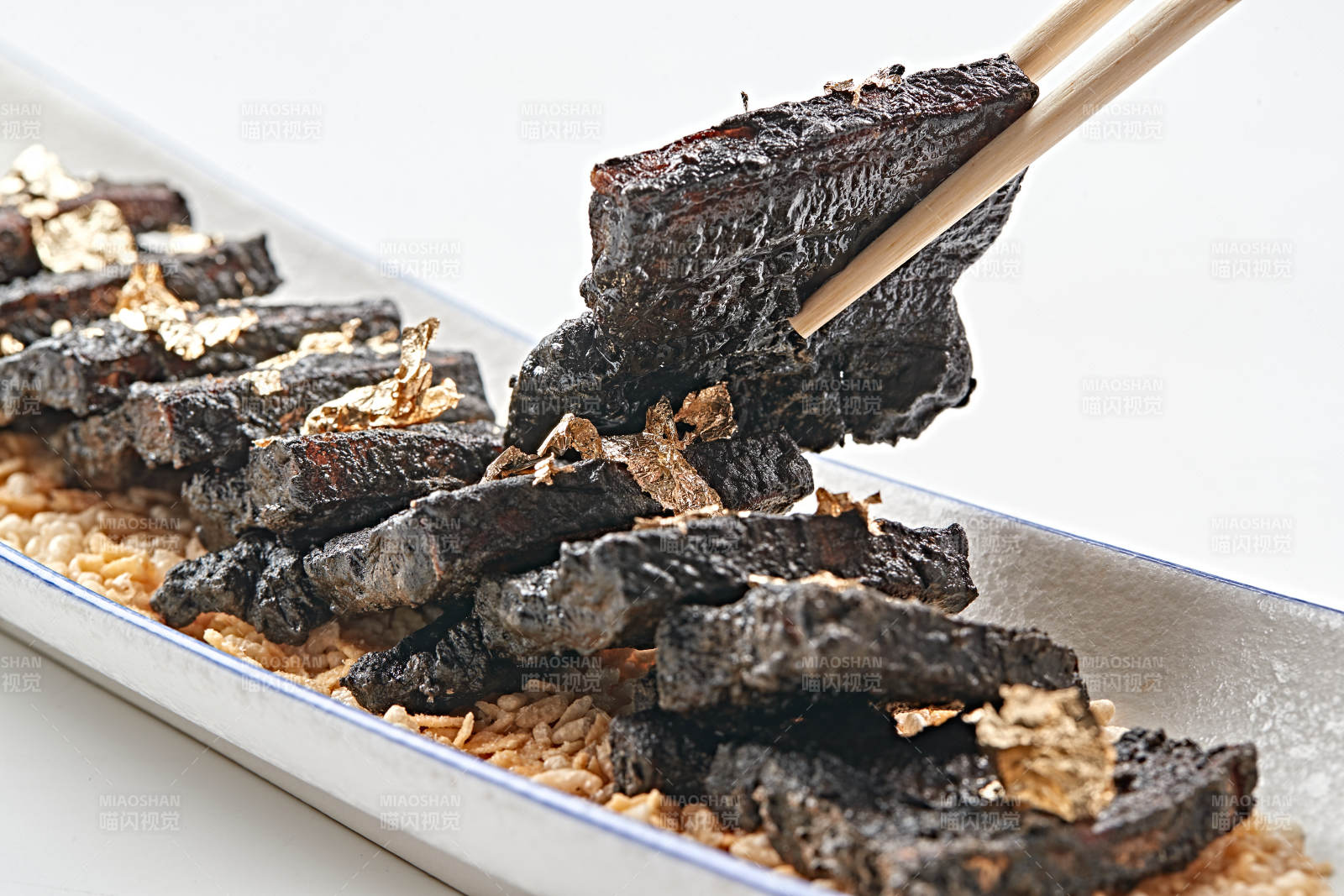 白色瓷盘装的墨鱼汁香煎猪五花肉图片