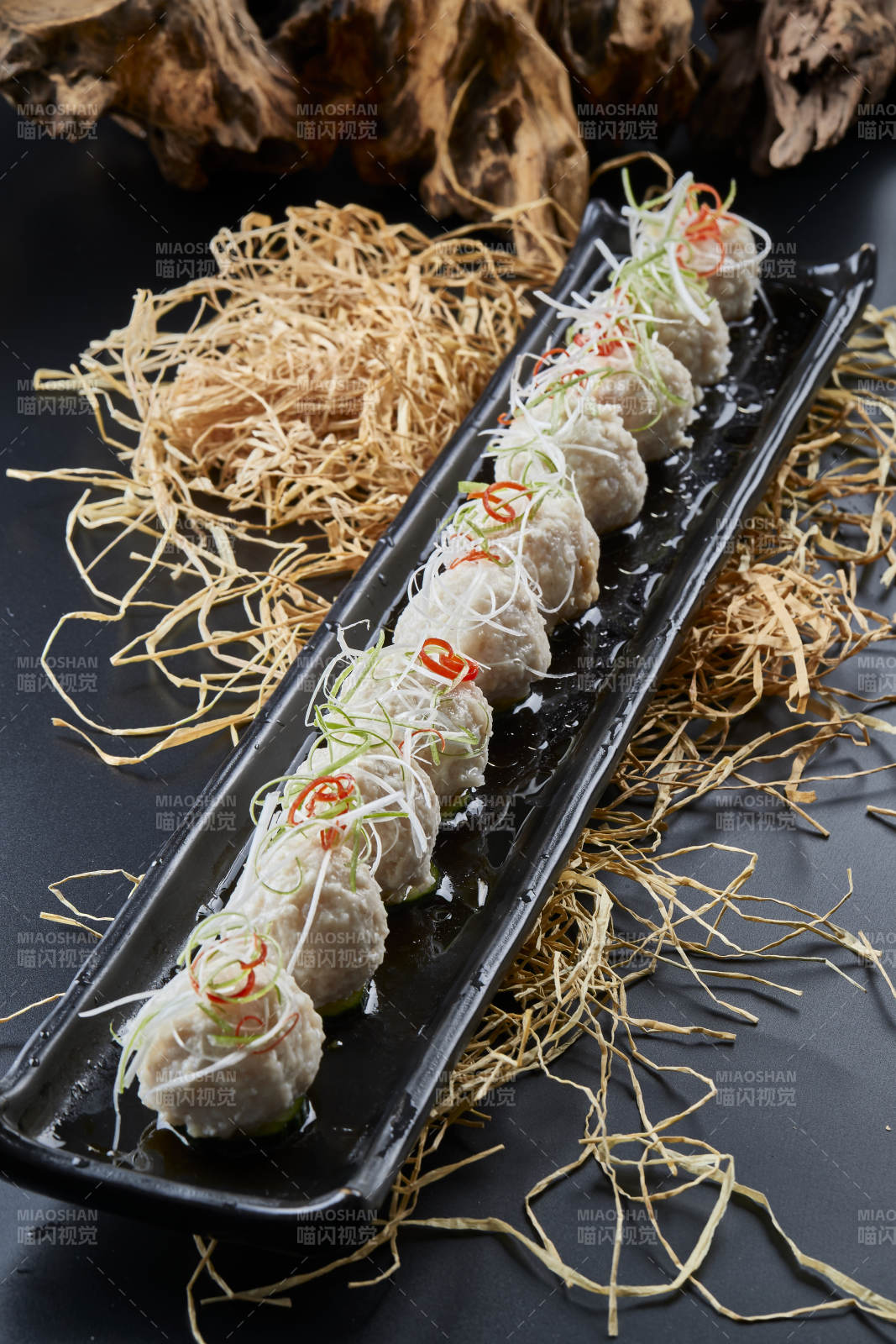 黑长瓷盘装的浇汁清汤萝卜丸子图片